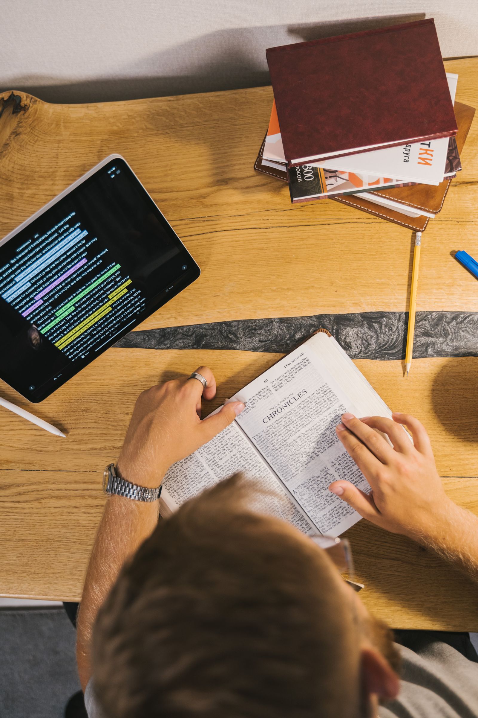 A person reading Scripture with a Bible and tablet